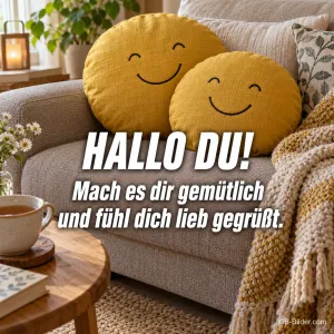 Zwei lächelnde Kissen auf dem Sofa, Text: Hallo du! Mach es dir gemütlich und fühl dich lieb gegrüßt.