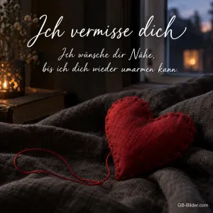 Rotes Stoffherz auf dunkler Decke, Text: Ich vermisse dich