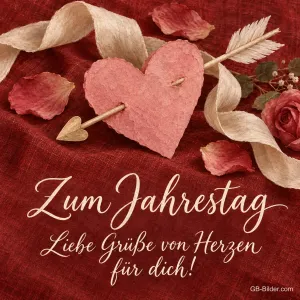 Papierherz mit Pfeil auf rotem Stoff, Text: Zum Jahrestag – Liebe Grüße von Herzen für dich!