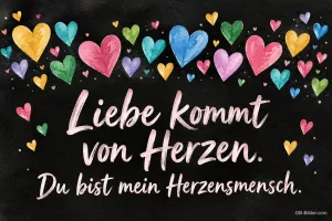 Bunte gemalte Herzen auf einer Tafel, Text: Liebe kommt von Herzen. – Du bist mein Herzensmensch.
