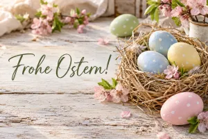 Pastellfarbene Ostereier im Nest, Text: Frohe Ostern!