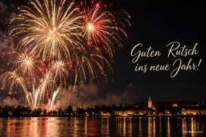 Feuerwerk über einer Stadt am See, Text: Guten Rutsch – ins neue Jahr!