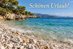 Kiesstrand an einer türkisen Bucht, Text: Schönen Urlaub!