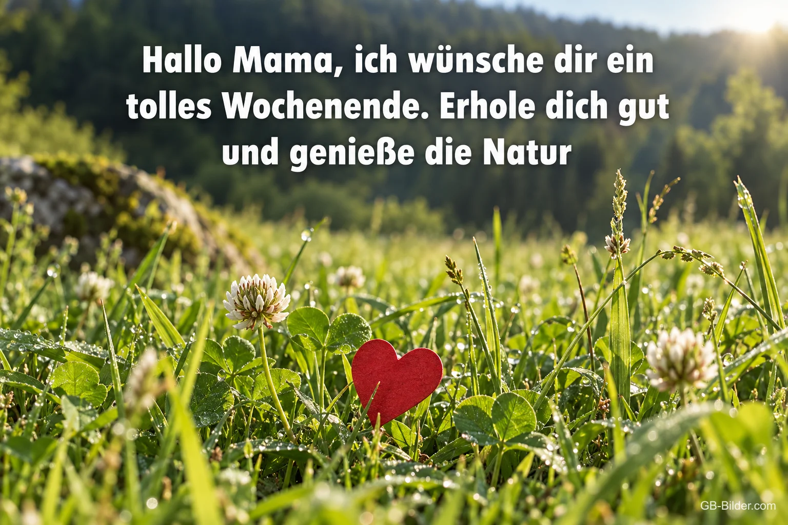 Rotes Herz zwischen Klee und Gras im Morgenlicht, Text: Hallo Mama, ich wünsche dir ein tolles Wochenende. Erhole dich gut und genieße die Natur