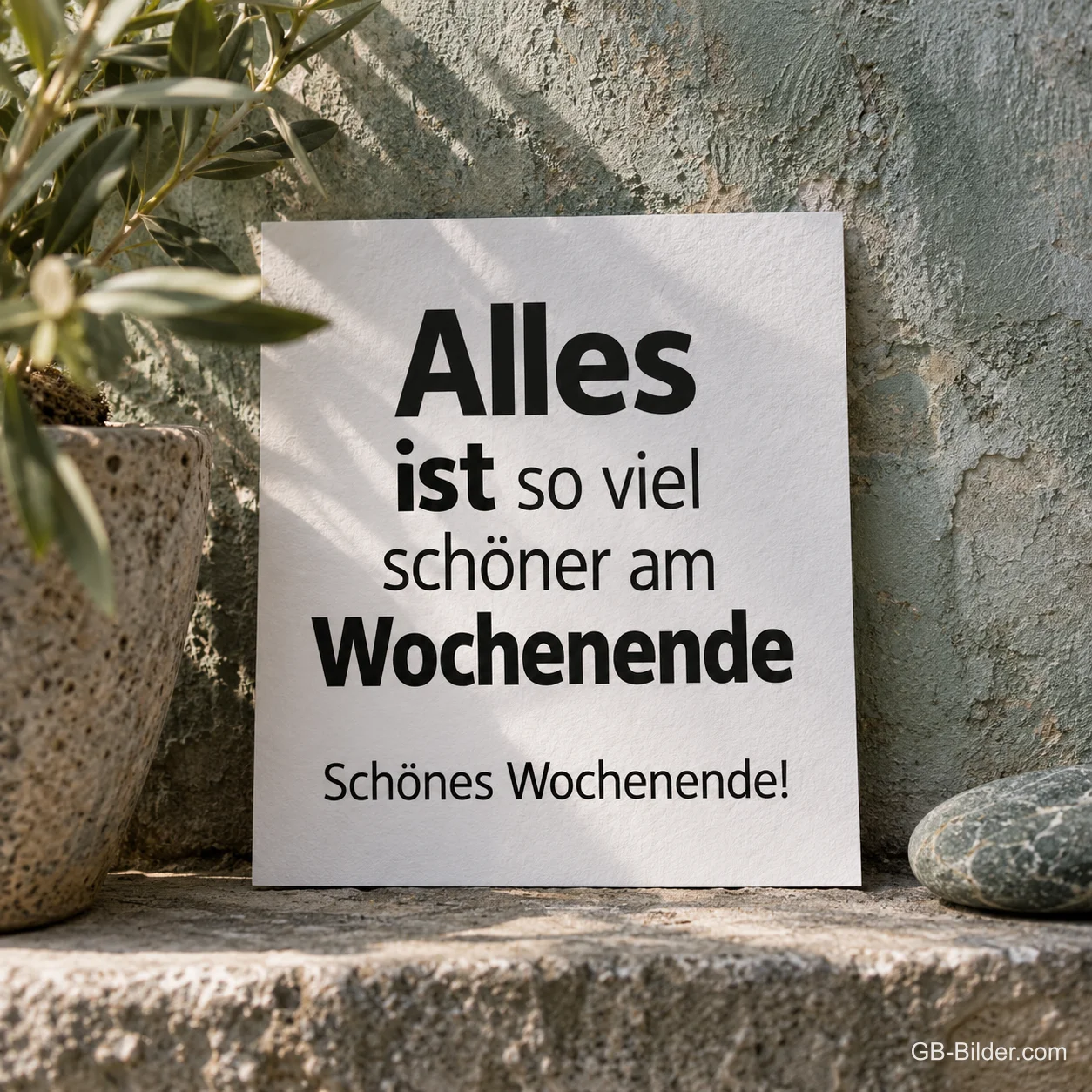 Weiße Karte an einer sonnigen Mauer, Text: Alles ist so viel schöner am Wochenende